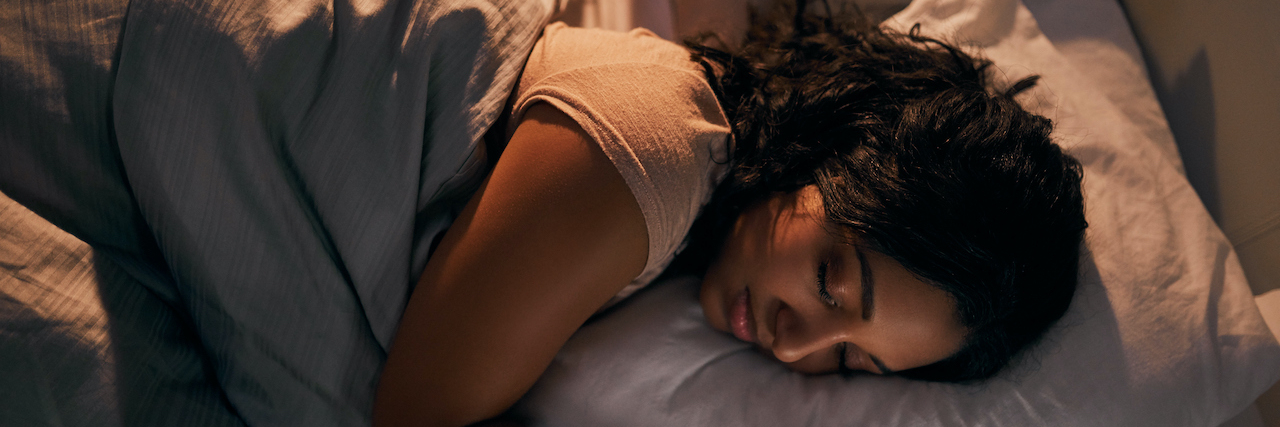 High angle shot of woman of color sleeping in bed at night