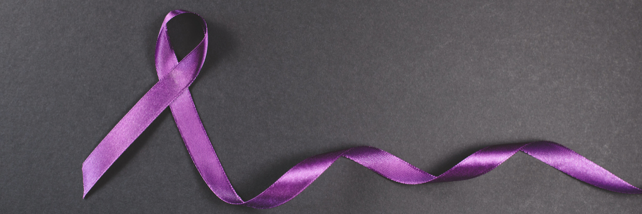 Purple ribbon on black background. Symbol of epilepsy awareness