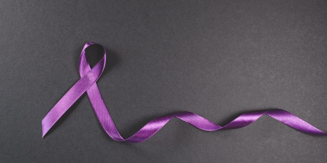 Purple ribbon on black background. Symbol of epilepsy awareness