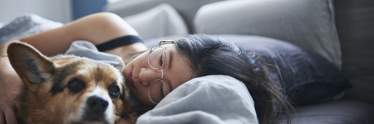 Can Dogs Sense Sadness? Canine Emotional Intelligence Woman lying in bed with dog