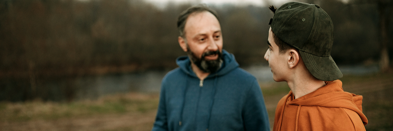 Cultivating Patience for Your Child With ADHD Father and son walking and talking together in a park