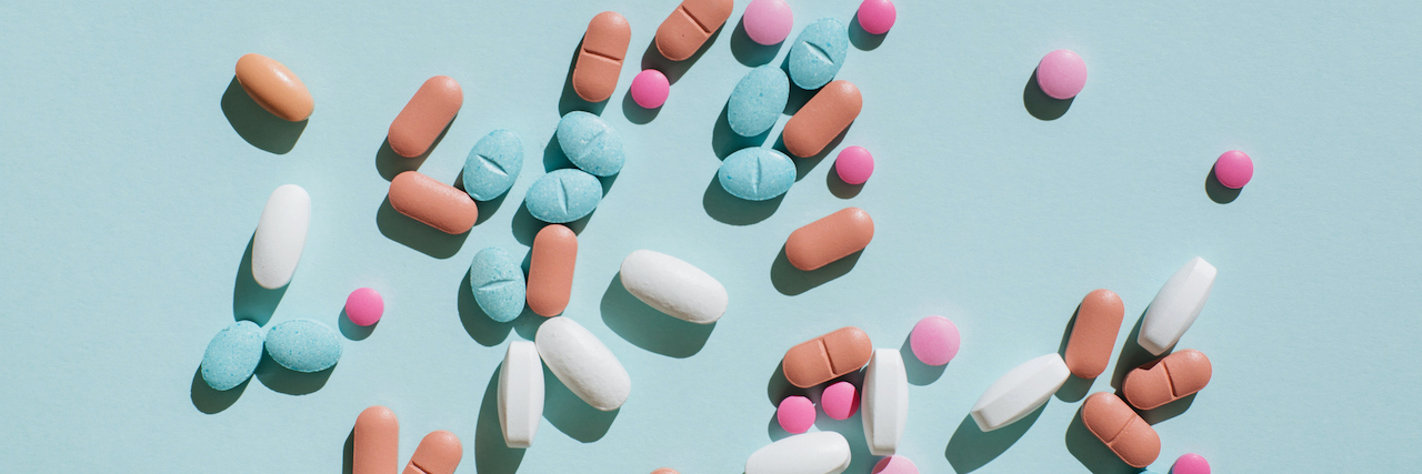 Everything You Need to Know About Epilepsy Medication Variety of pills and capsules on blue background.