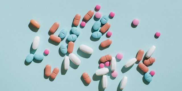 Inside the FDA Decision That Left Thousands of SCA Patients in Limbo Variety of pills and capsules on blue background.