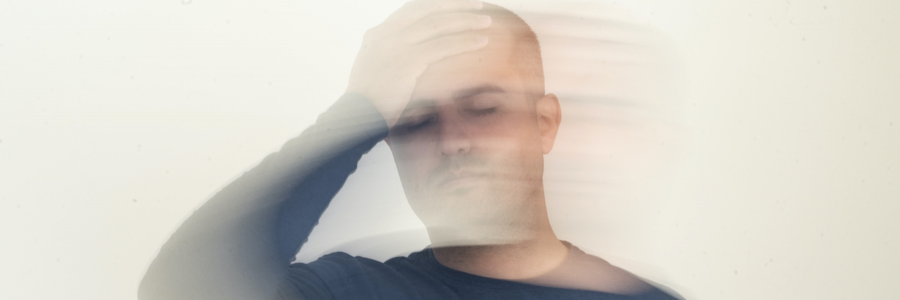Man holding his head with motion blur effect