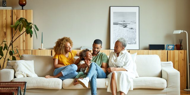 The Role of Genetics in Migraine Cheerful boy with parents and grandmother on sofa.