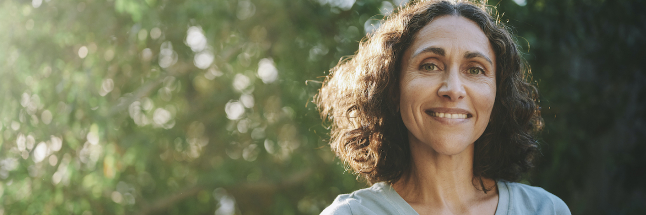 Does Epilepsy Go Away? How Epilepsy Changes As You Age Portrait of woman smiling outside in a park