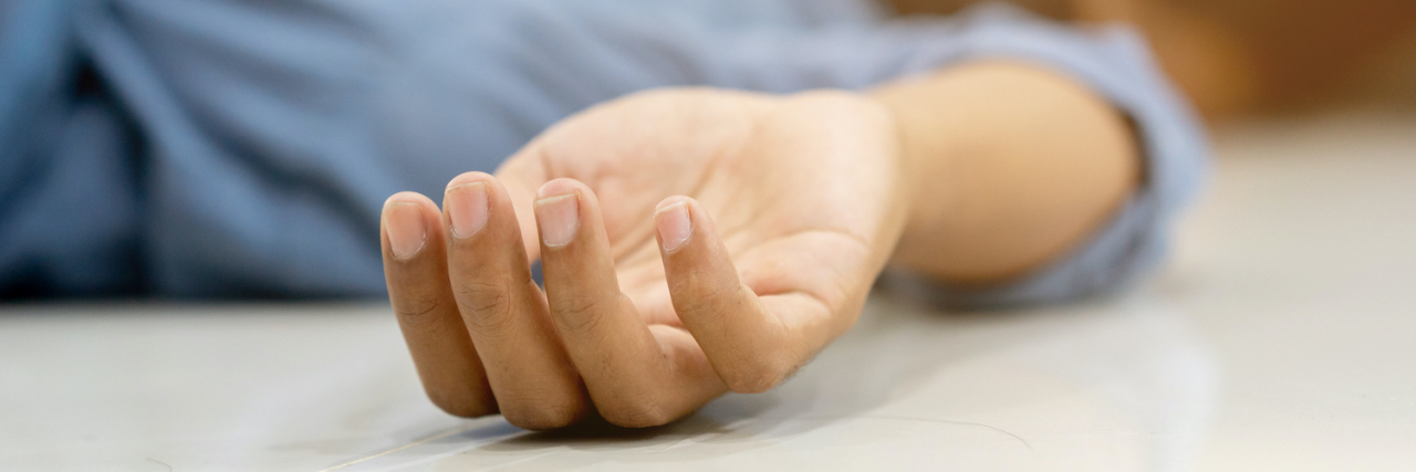 What to Do When Someone Has a Seizure Close up of hand of person laying on floor