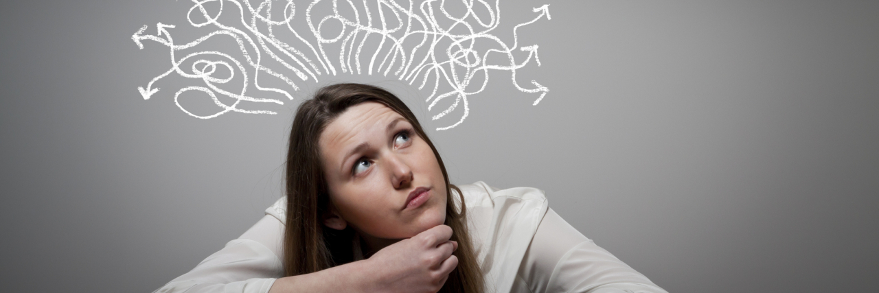 Can OCD Make You Believe Things That Aren’t True? A woman with many drawn arrows above her head implying her thinking.