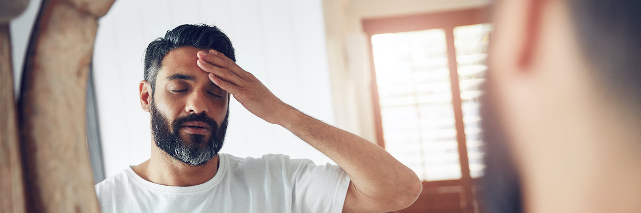 What Is Endogenous Depression? Man standing in front of the mirror looking exhausted