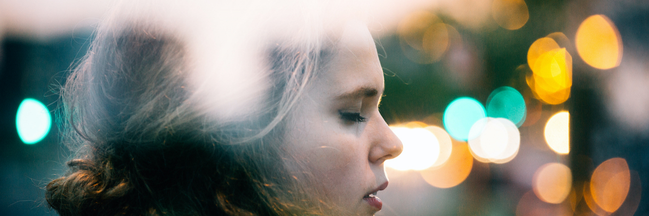 Can Flashing Lights Cause Seizures Without Epilepsy? Woman with eyes closed at night, out of focus lights surrounding her