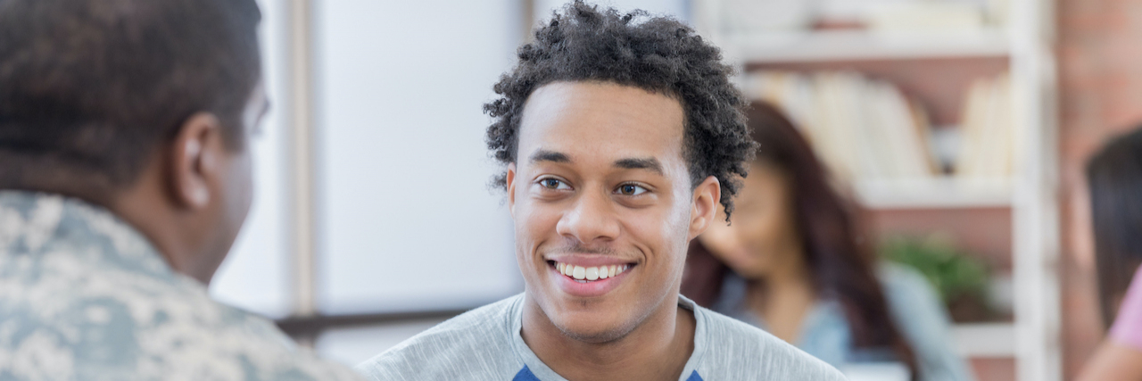 What You Need to Know About Joining the Military With Epilepsy Young Black man talks with military officer at recruitment event