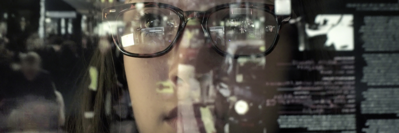 Is OCD a Disability? Your Questions Answered A person looking through a translucent screen with lines of computer data.