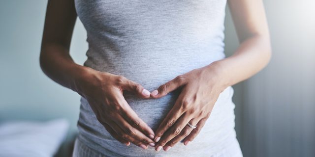 How to Treat Migraine in Early Pregnancy Cropped shot of a pregnant woman of color holding her hands in heart shape over her belly