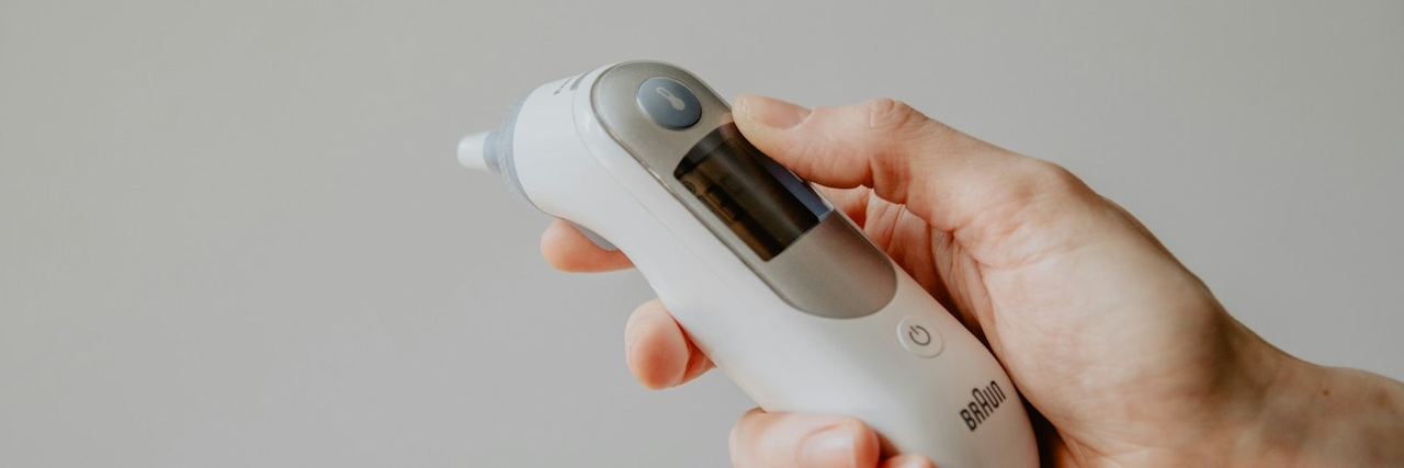 What Body Temperature Can Tell Us About Depression Person's hand holding a thermometer