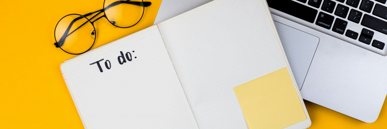 How to Build a New Routine While Job Hunting With ADHD Glasses, ear buds, pen and notebook with "To do" at the top next to an open laptop