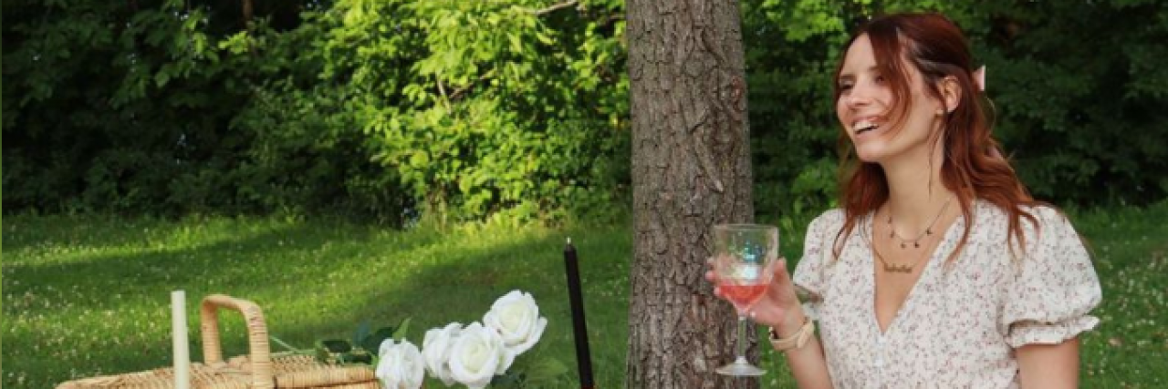 What Helped Me Most in My Bipolar Journey Contributor sitting on blanket outside holding a glass and having a picnic