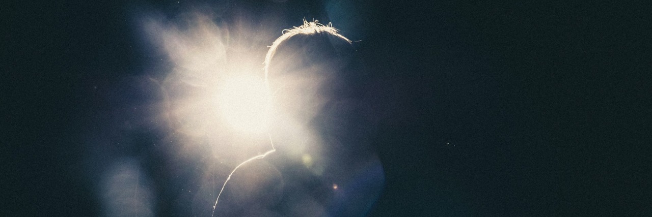 How I Found Hope Living With Depression Silhouette of a person standing in the dark with a light behind them
