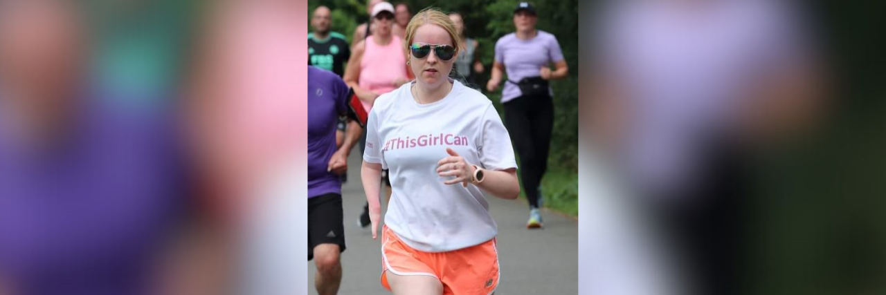 How Running Helps Me Cope With Depression Contributor running in sunglasses and wearing a tshirt that reads "#ThisGirlCan"