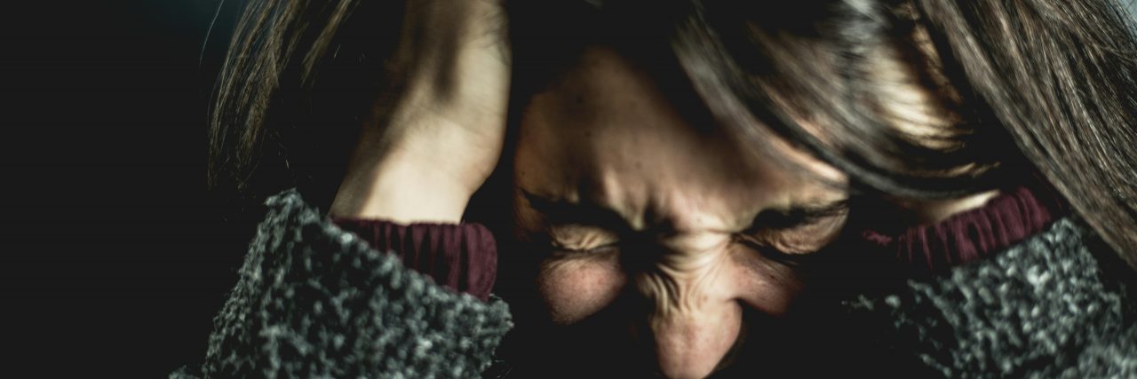Person holding their head in pain.
