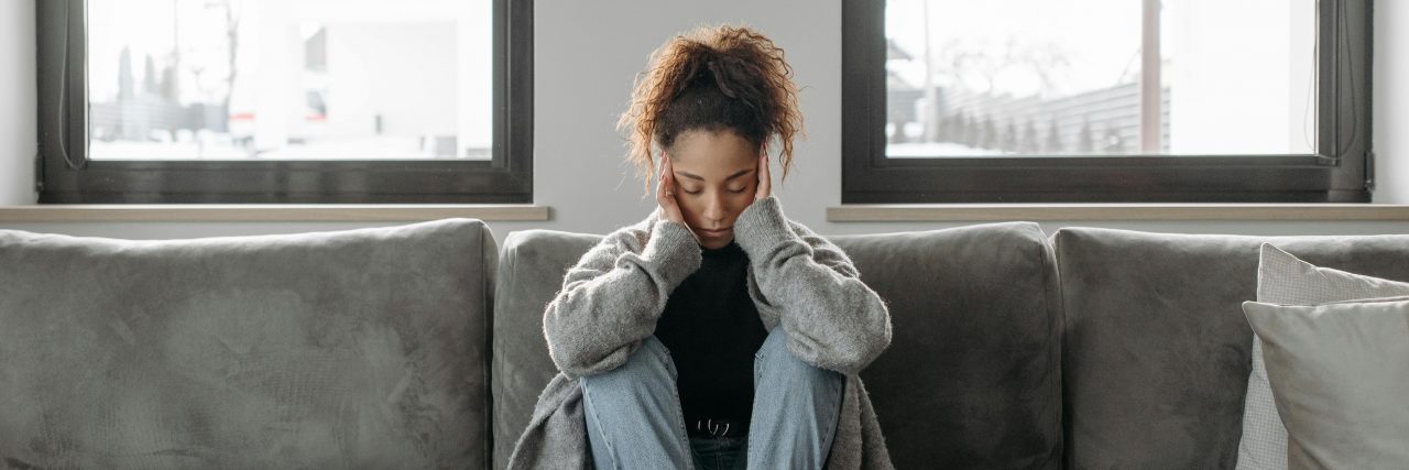Person sitting on couch with headache
