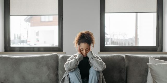 Person sitting on couch with headache