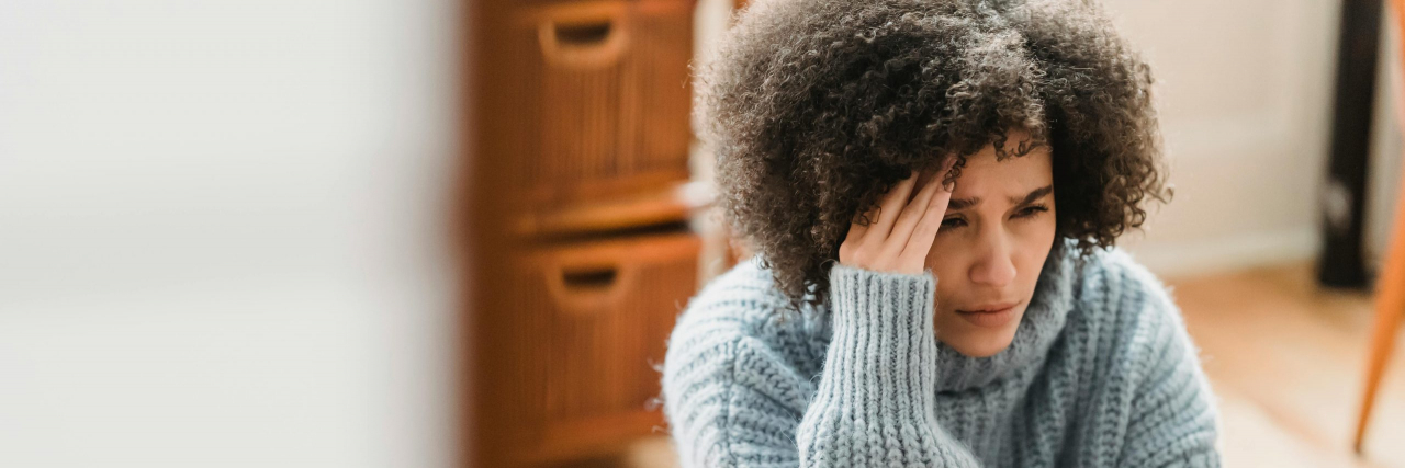 person with migraine looking depressed