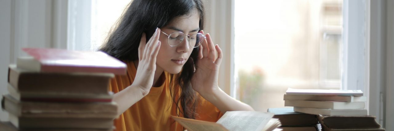 woman with migraine while studying