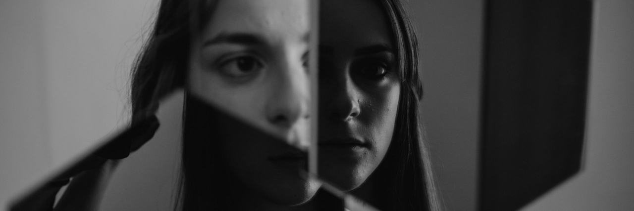 person looking in a broken mirror