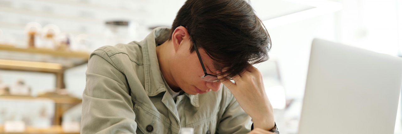 Awkward Migraine Symptoms man with migraine at computer