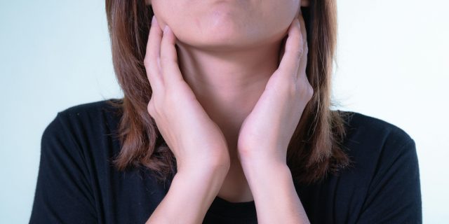 person holding sore throat
