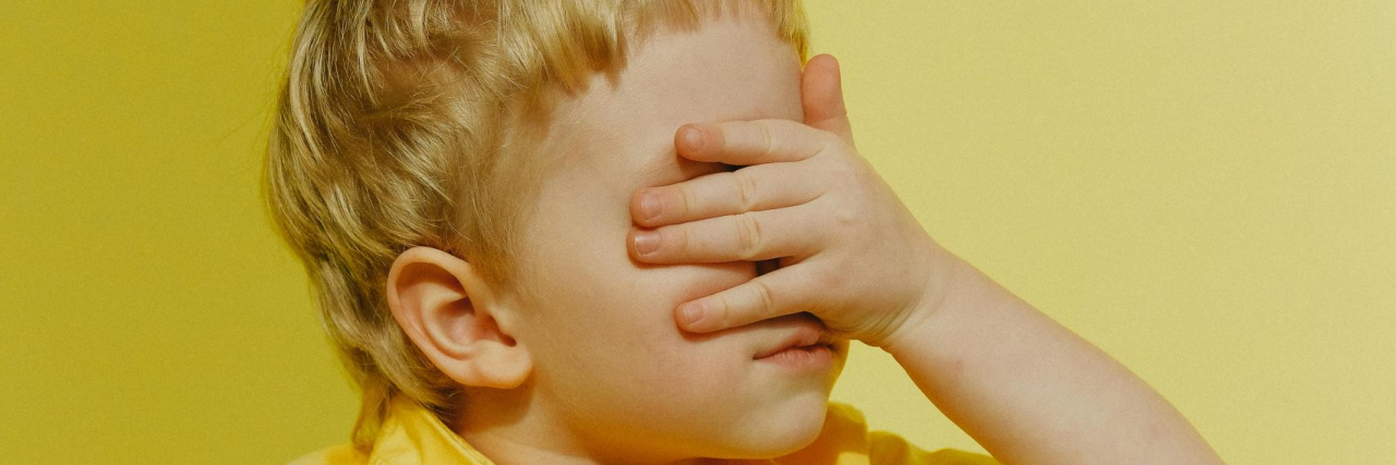 boy covering his eyes