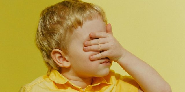 boy covering his eyes