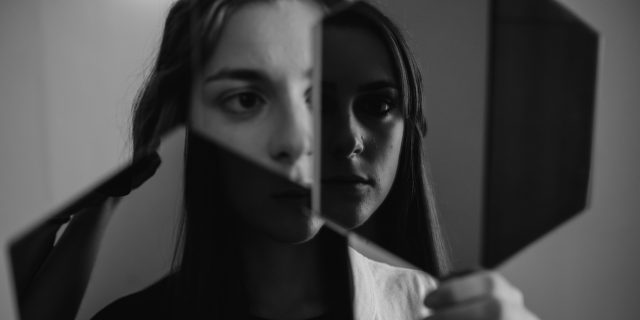 person looking in a broken mirror