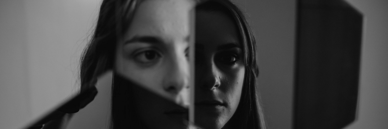 Unusual Symptoms of Psychosis You Might Not Know About person looking in a broken mirror