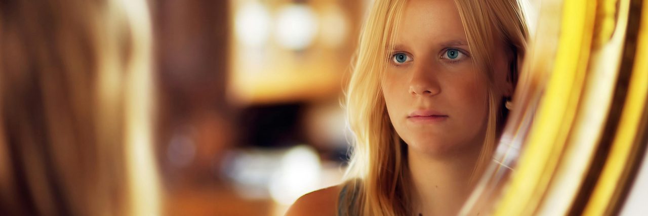 Signs of Covert Narcissism woman looking in a mirror