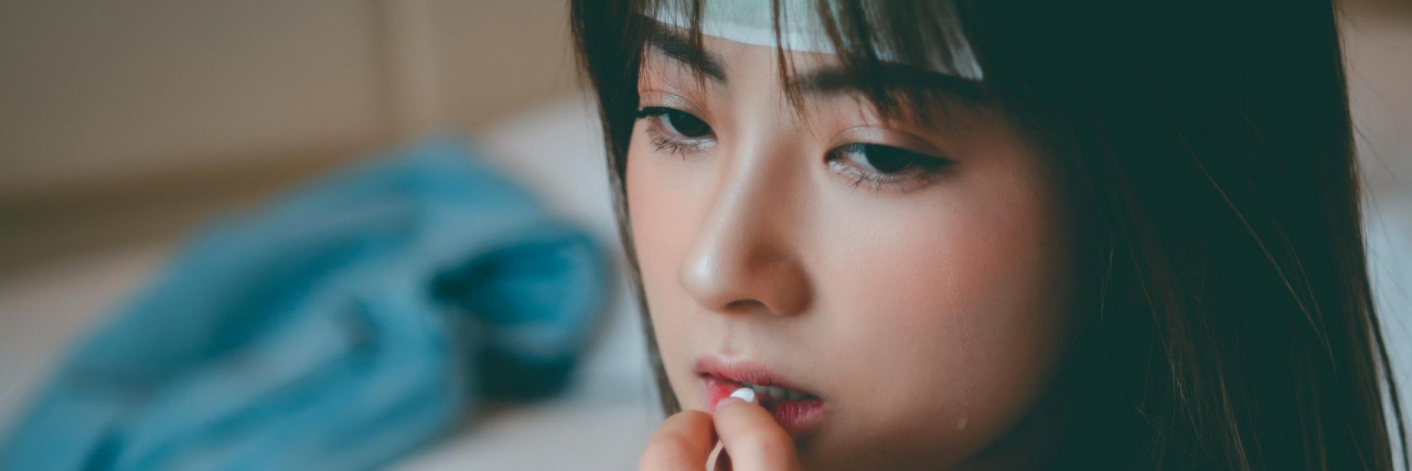 Migraine vs. Meningitis Headache: How to Tell the Difference (and When It’s an Emergency) person taking medicine for a headache