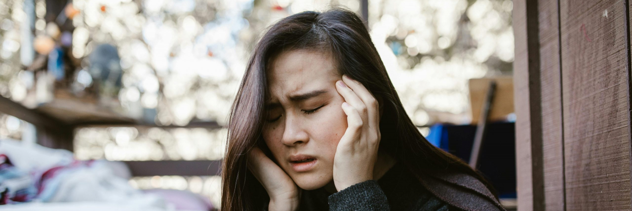 person with migraine outside