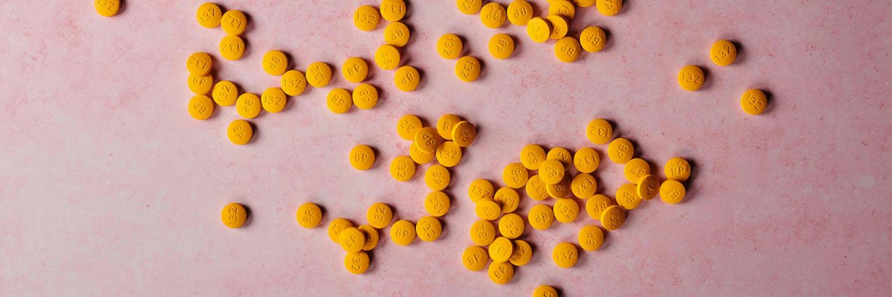 orange pills on pink background