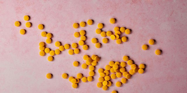 orange pills on pink background