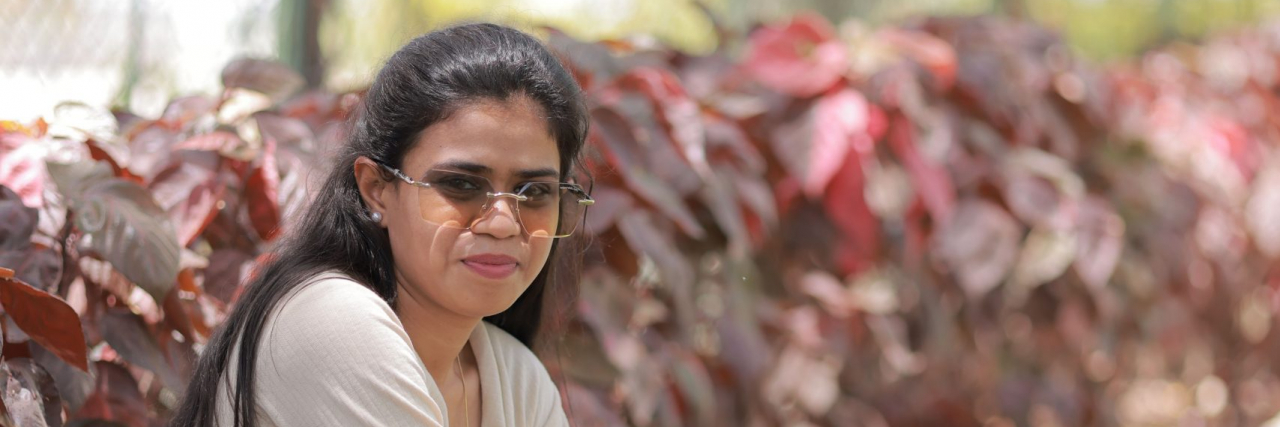 Self-Care for AuDHD: 12 Strategies That Actually Work person sitting outside with sunglasses on, thinking