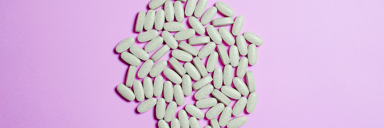 Magnesium and Migraine magnesium pills with a pink background