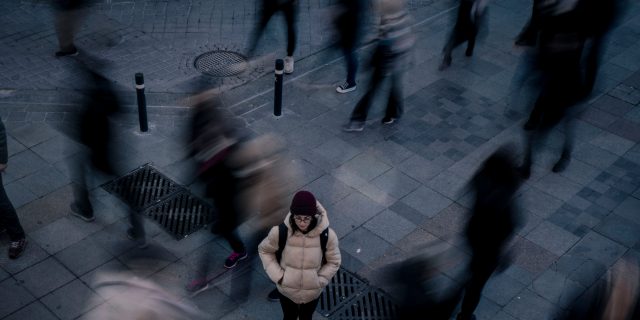 person alone in a crowd