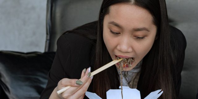 person eating spicy takeout